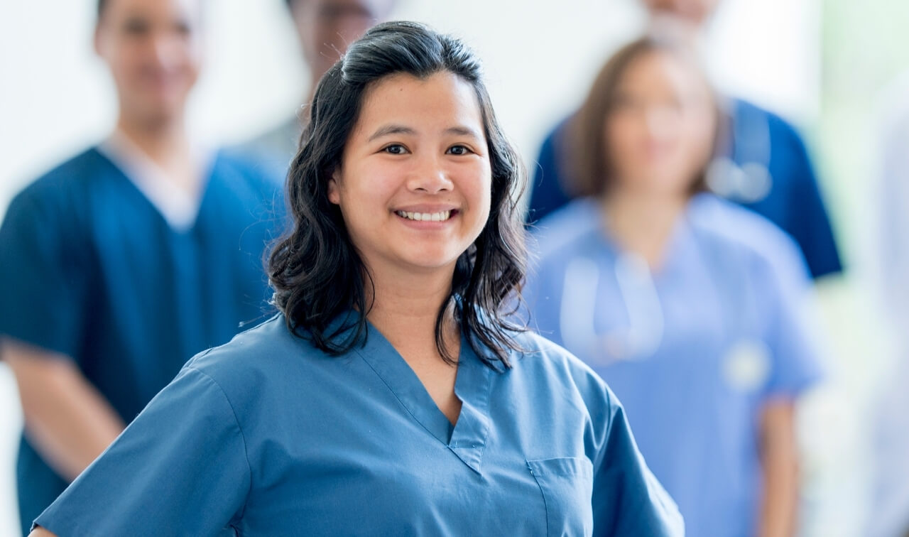 Portrait of Nurse Practitioner in front of team of nurses